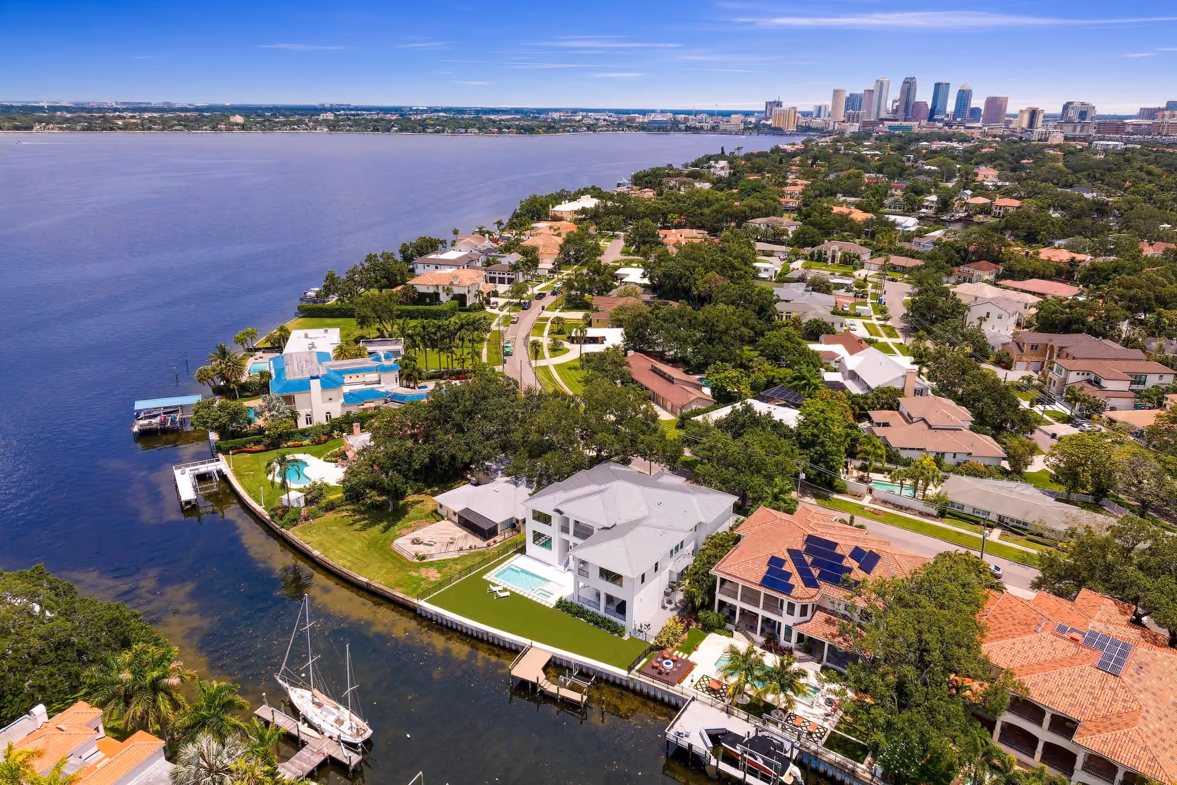 Aerial view of waterfront homes on Tampa Bay with the downtown Tampa skyline in the distance