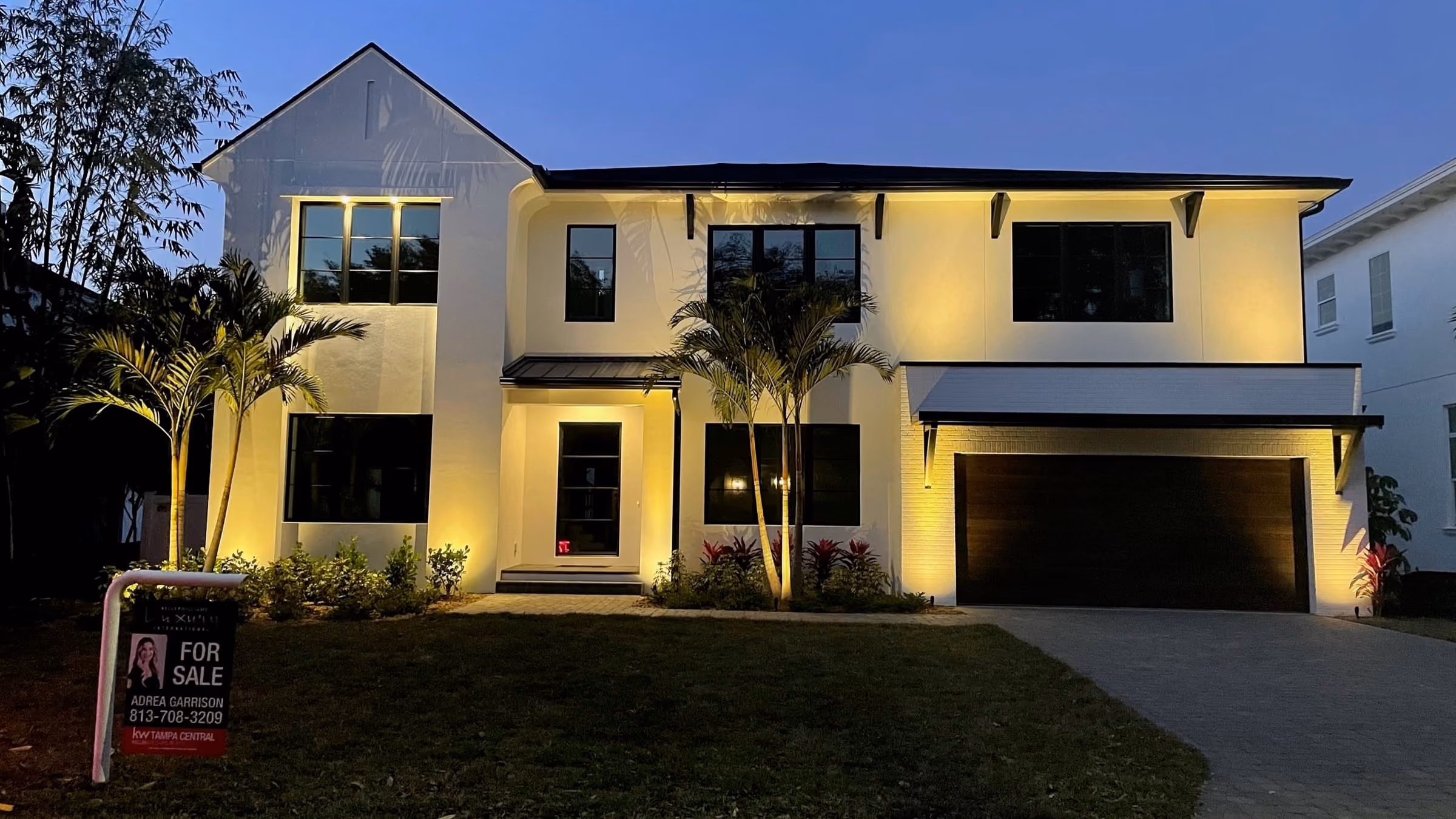 Two-story home lit up at dusk
