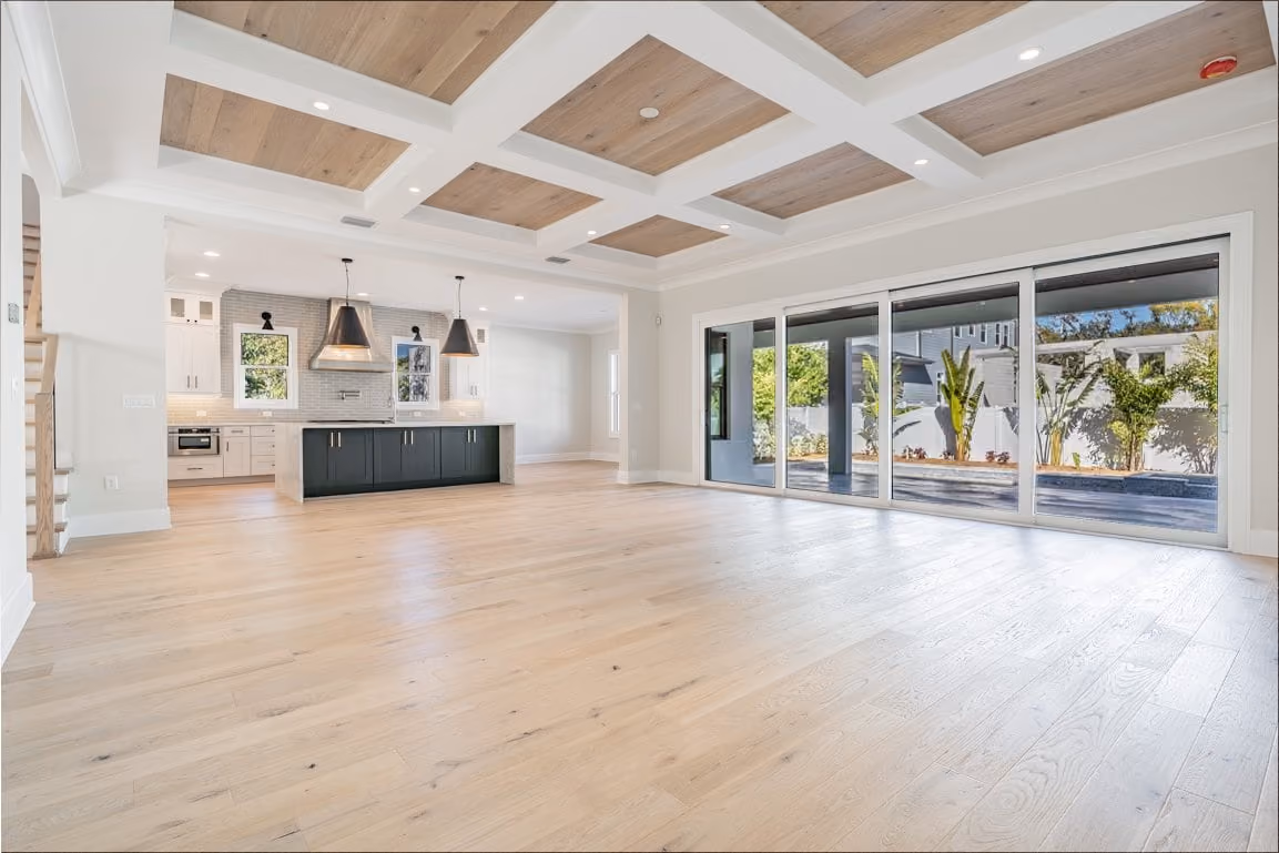 Great room with a coffered ceiling, oak floors and a sliding glass wall