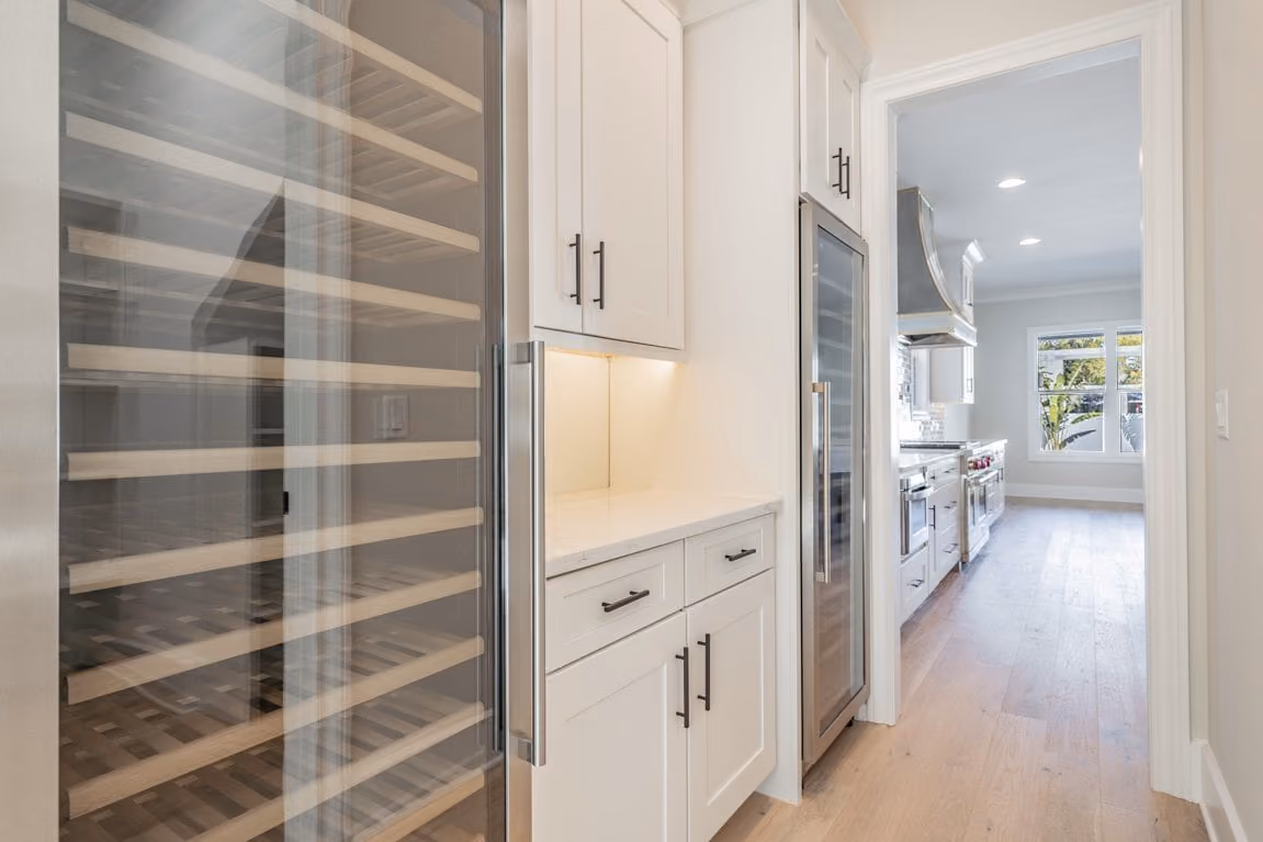Floor-to-ceiling wine cooler set into white cabinetry