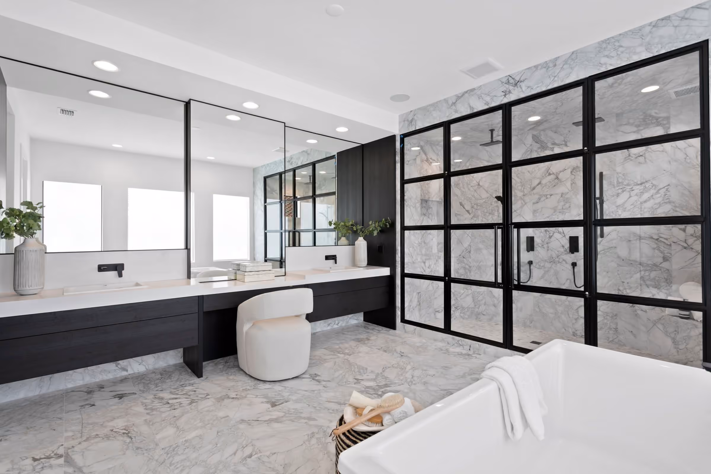 Primary bath with a black steel-framed glass shower and a soaking tub