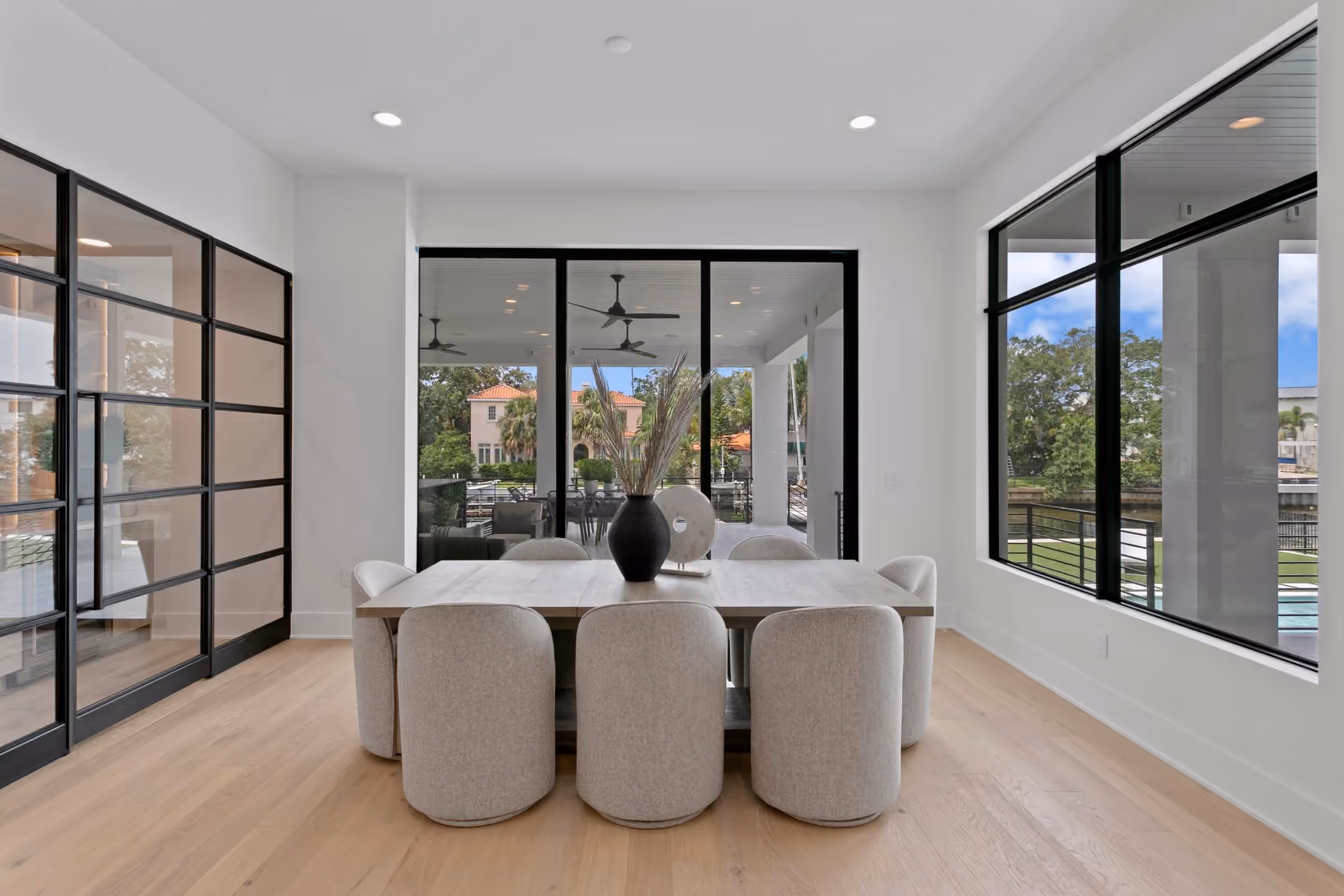Dining room beside a steel-framed glass wall with a view of the canal