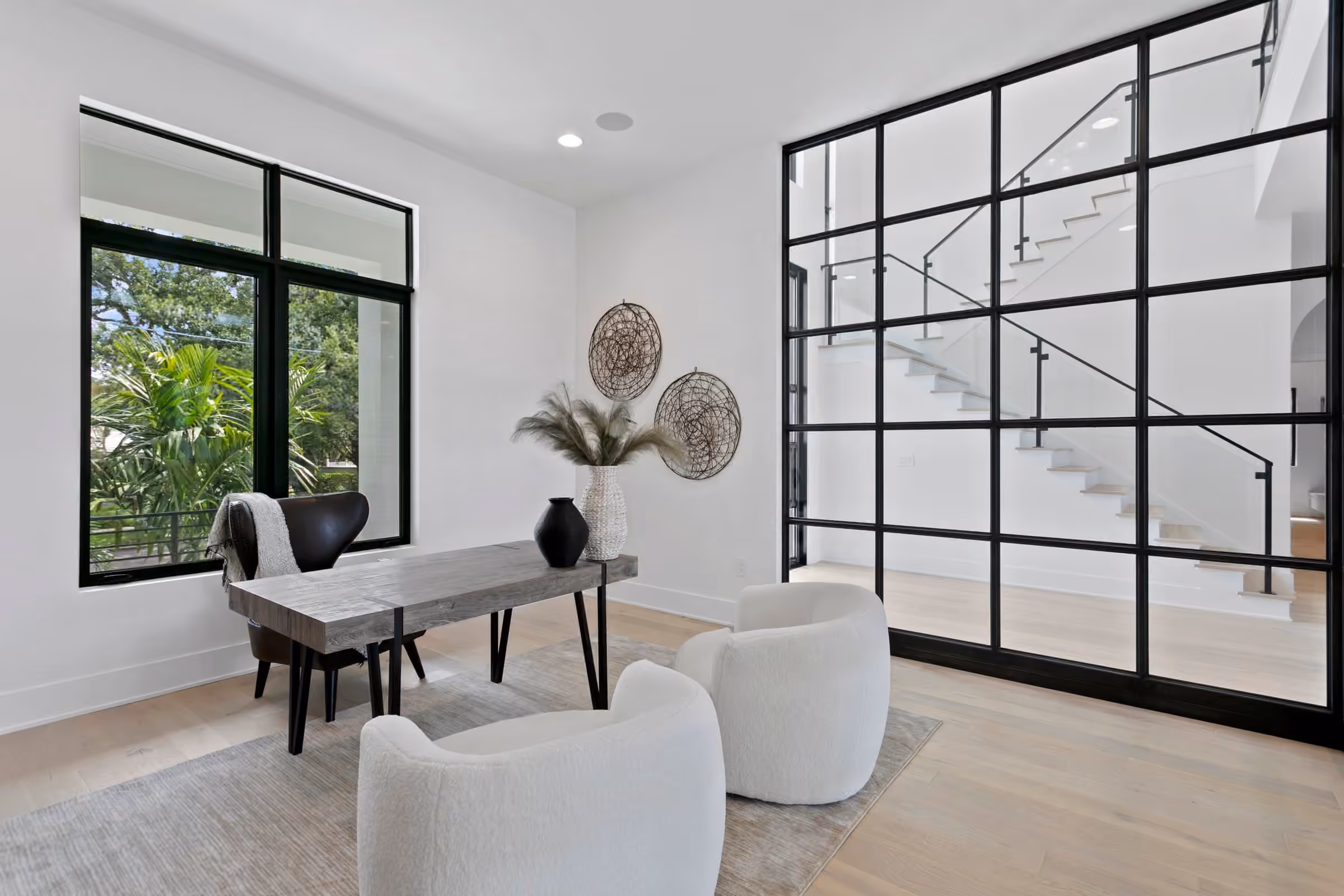 Home office behind a steel-framed glass wall next to the stair