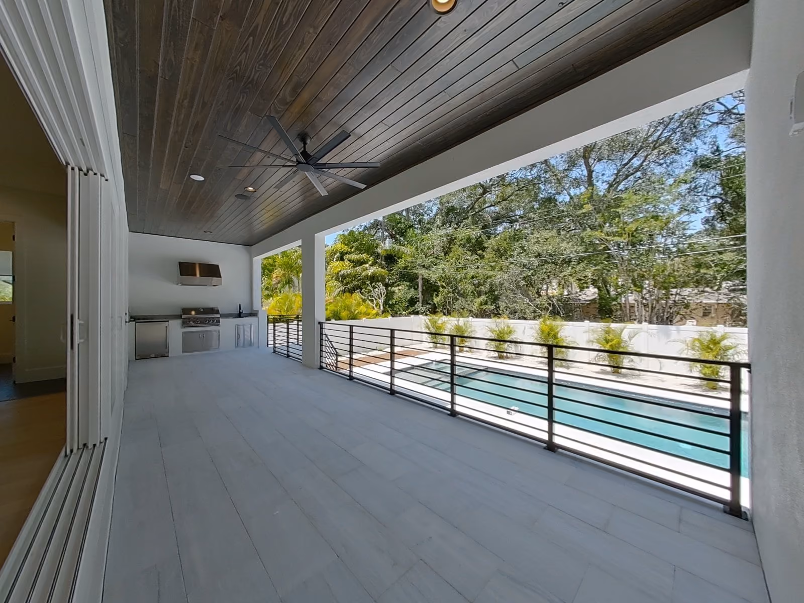 Covered patio with a wood ceiling looking out to the pool