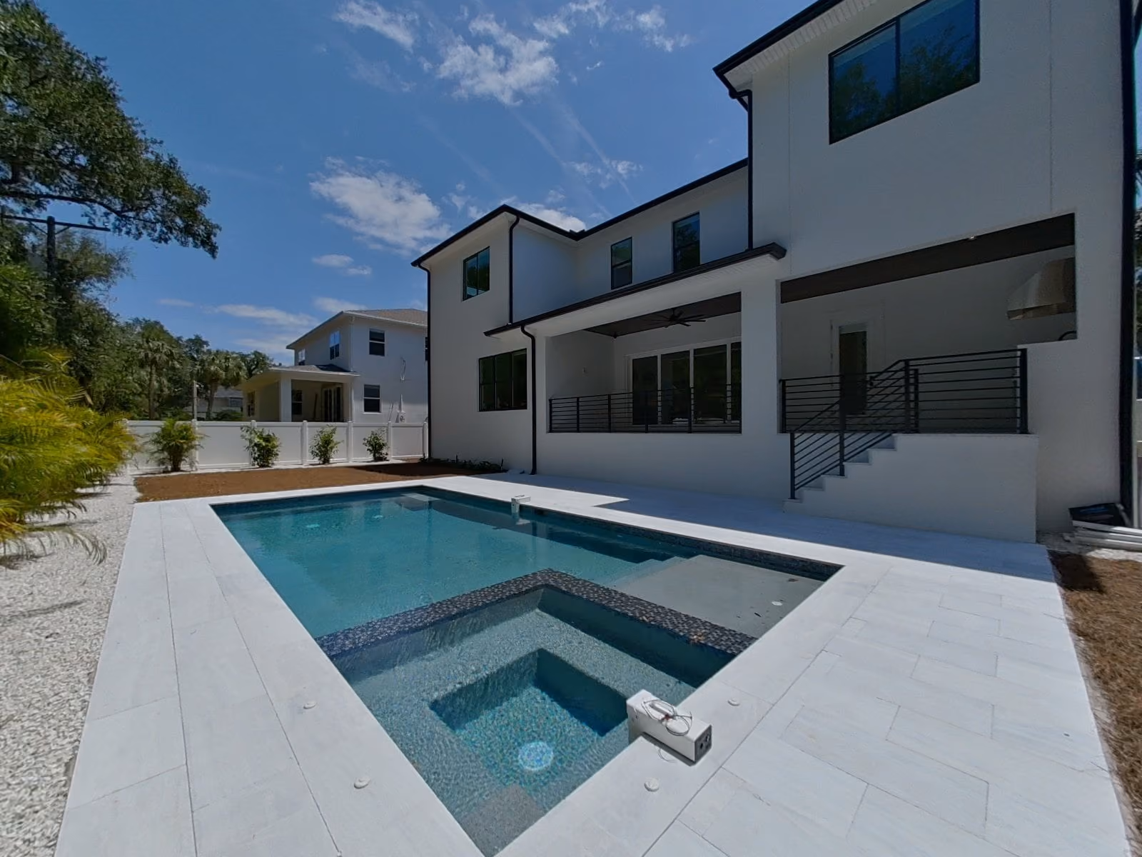 Pool and spa behind a two-story home