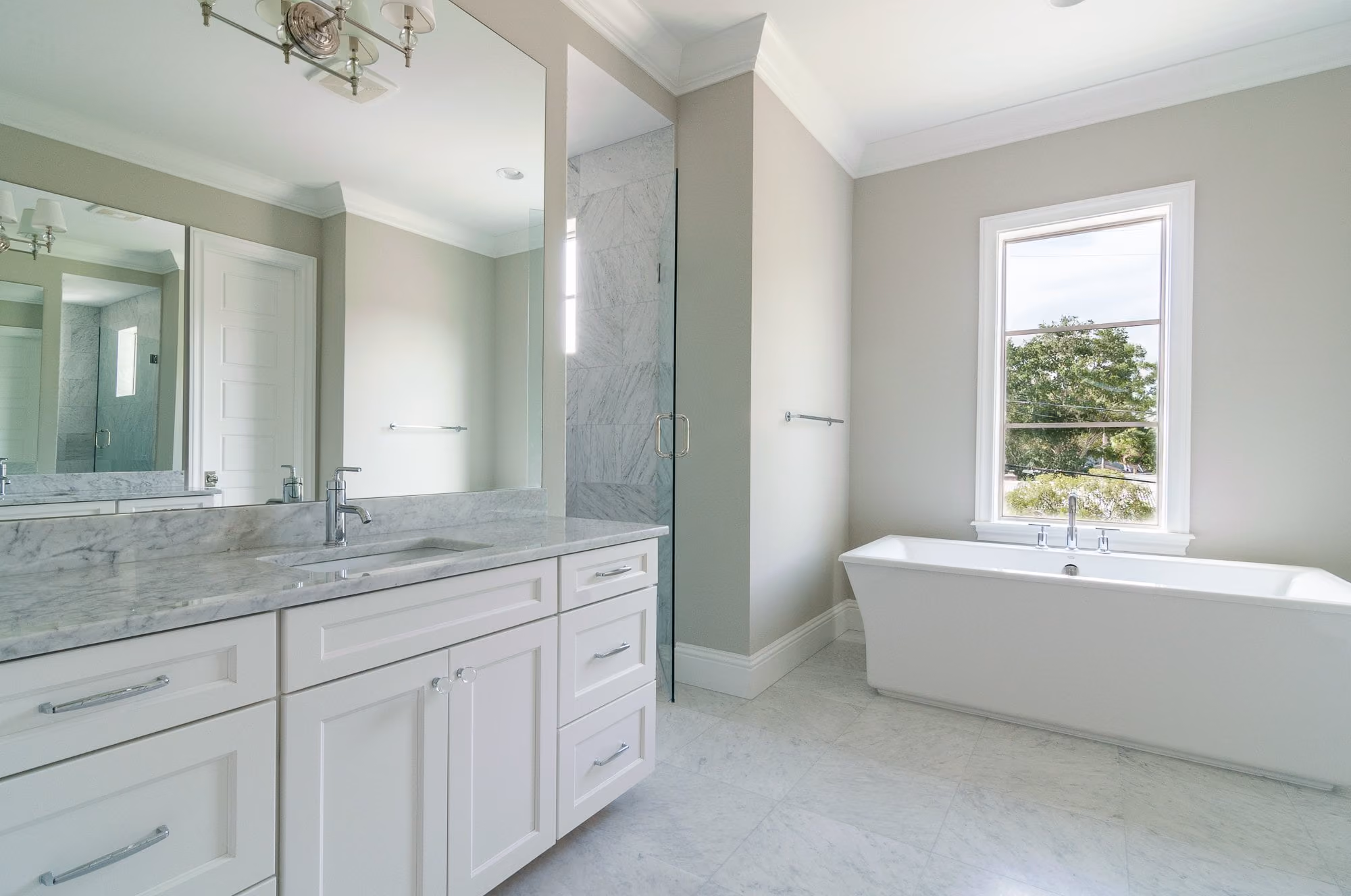 Bathroom with a freestanding tub and a granite vanity