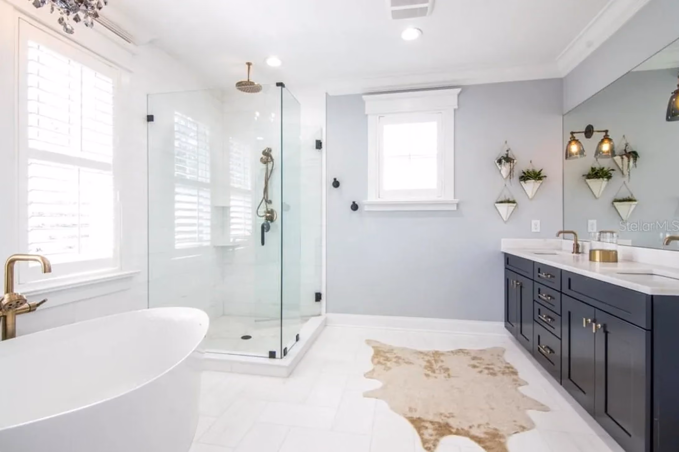 Bathroom with a soaking tub, a glass shower and a dark vanity