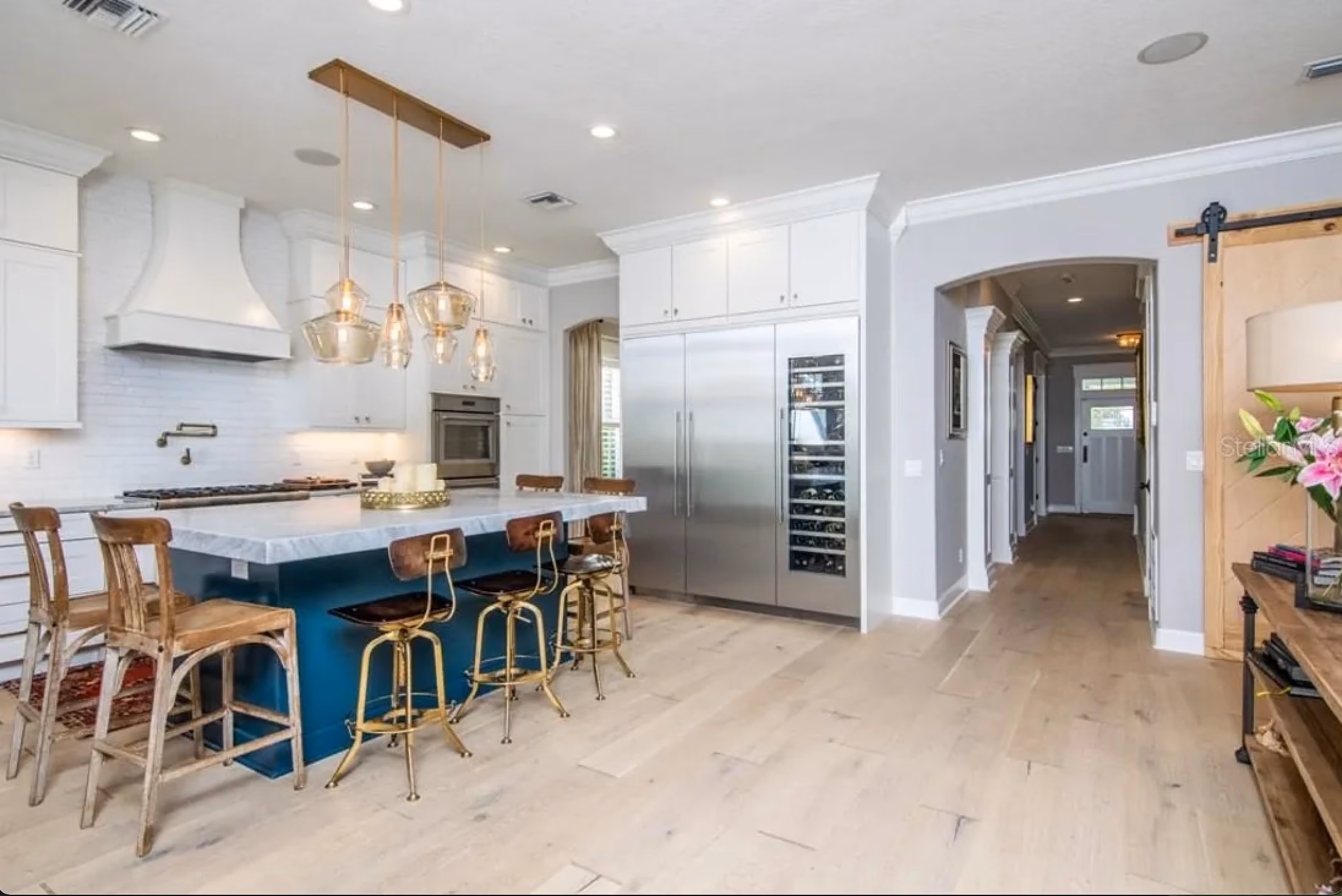 Kitchen with a blue island and bar stools