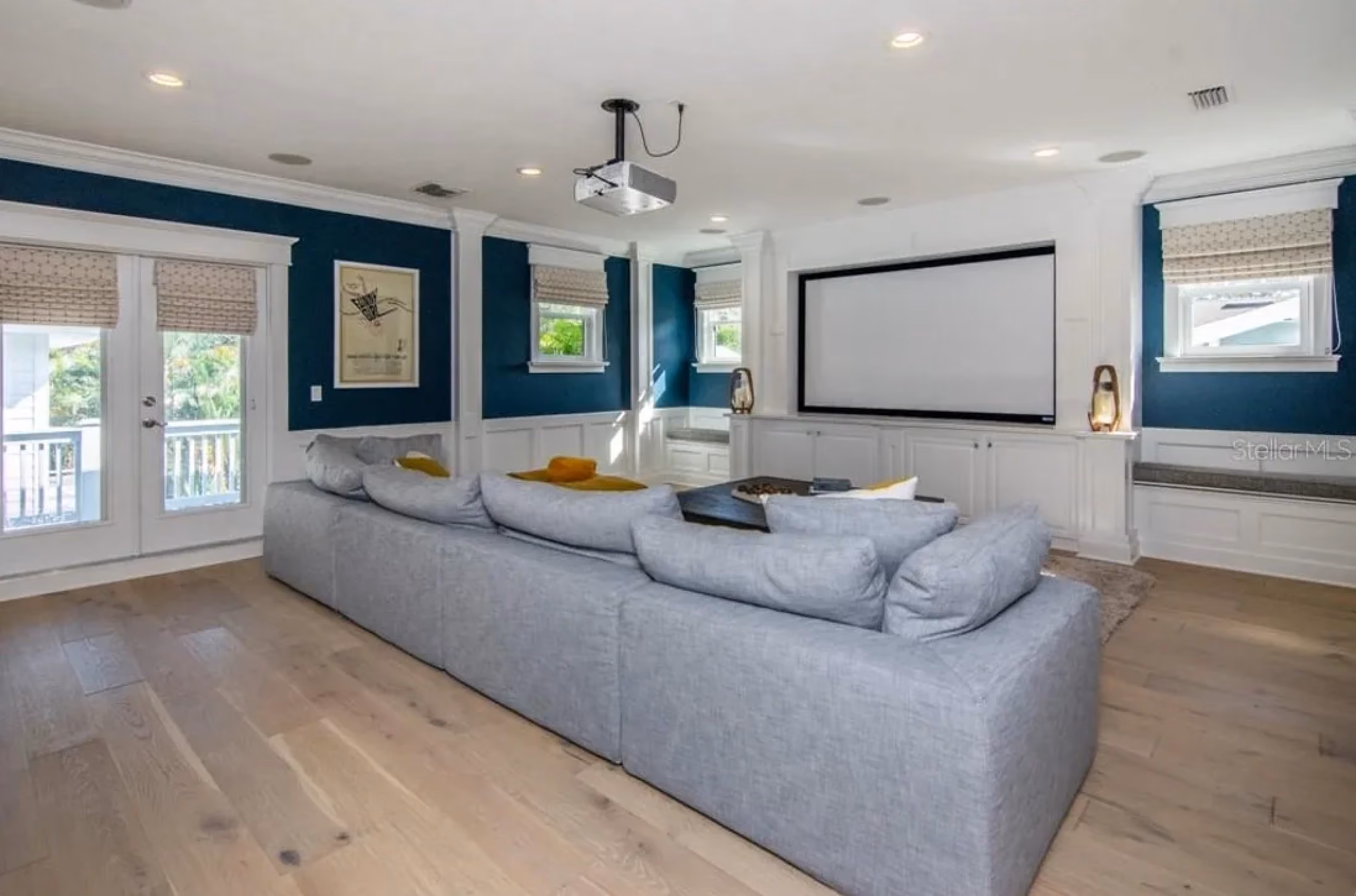Media room with a projector screen and a gray sectional